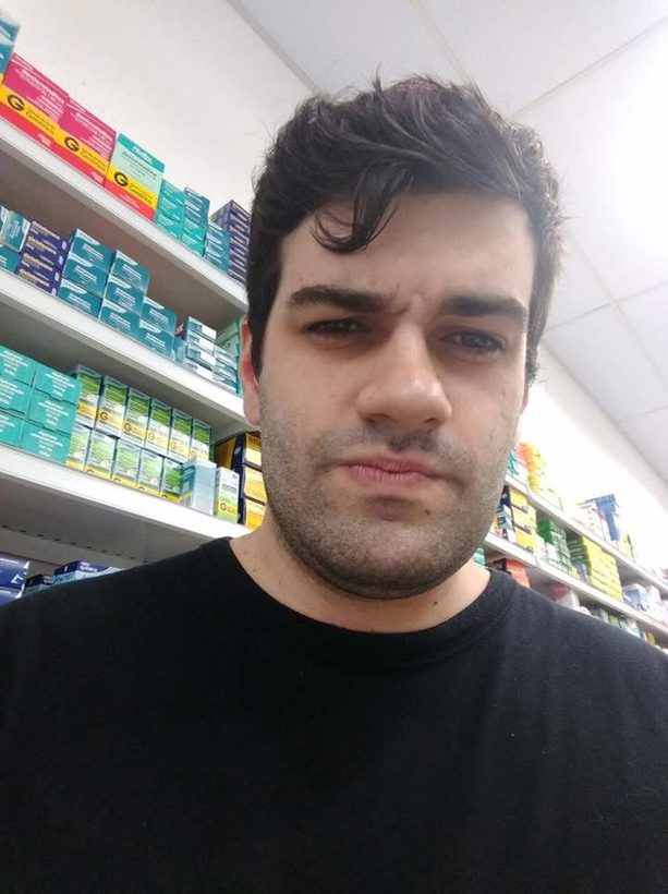 Selfie de Anderson com prateleiras de remédios ao fundo.